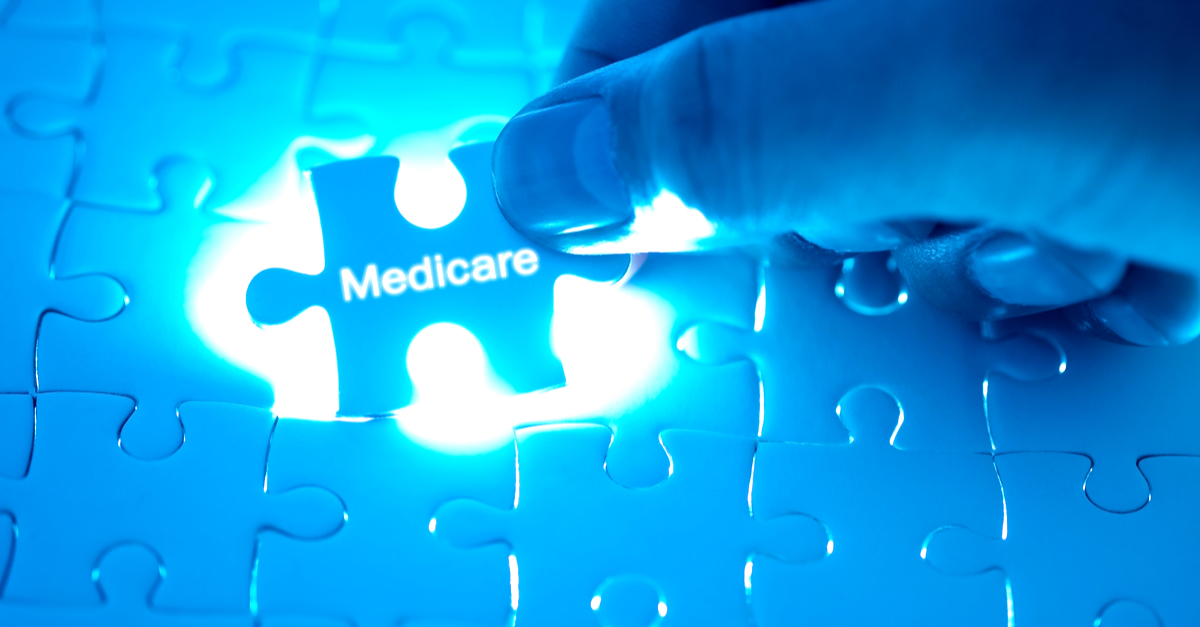 ealth Care Concept. Doctor holding a jigsaw puzzle with medicare word.