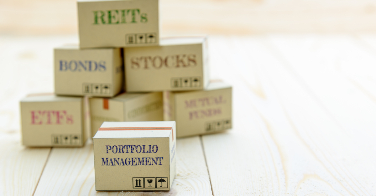 Portfolio and wealth management with risk diversification concept : Small paper cartons / boxes of financial instruments i.e ETFs, REITs, stocks, bonds, mutual funds and commodities, on a wood table.